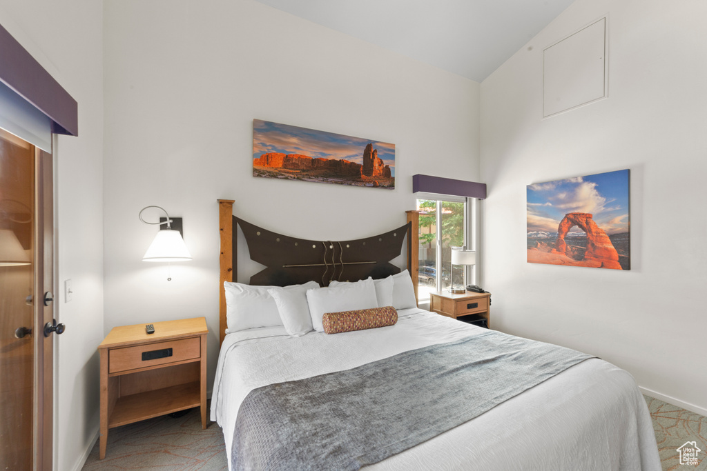Carpeted bedroom featuring baseboards and vaulted ceiling