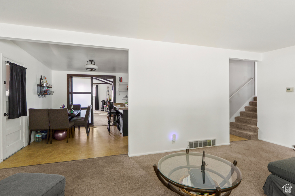 Carpeted living area with stairway
