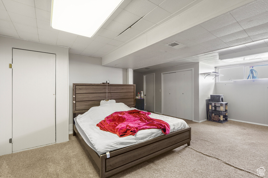 Carpeted bedroom with a paneled ceiling