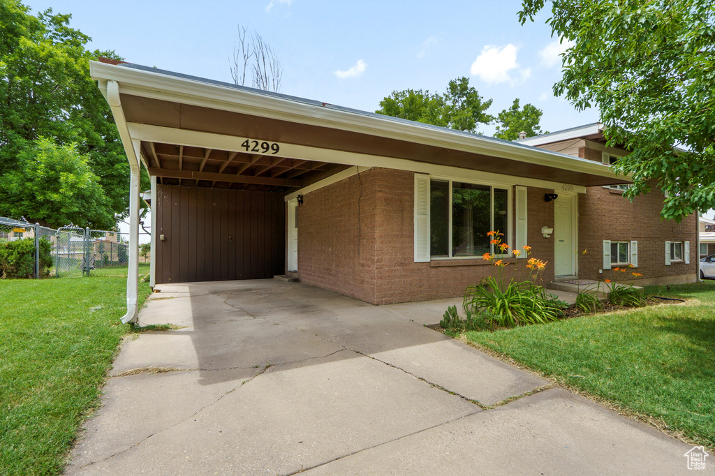 View of front of property with concrete driveway, an attached carport, and brick siding