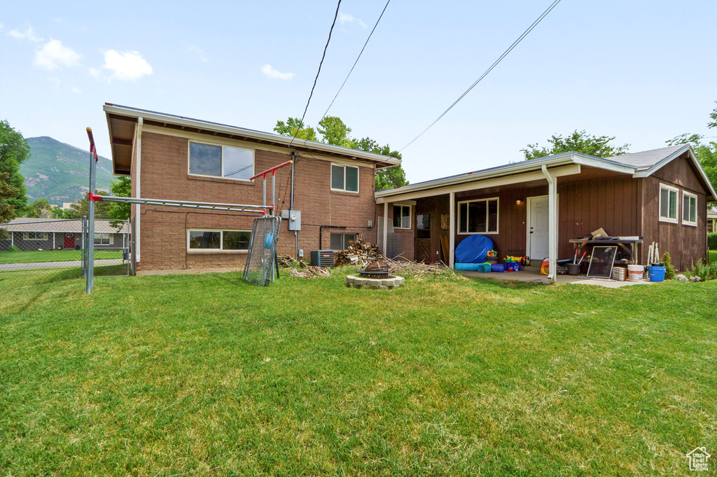 Back of property featuring an outdoor fire pit, a patio, and a mountain view