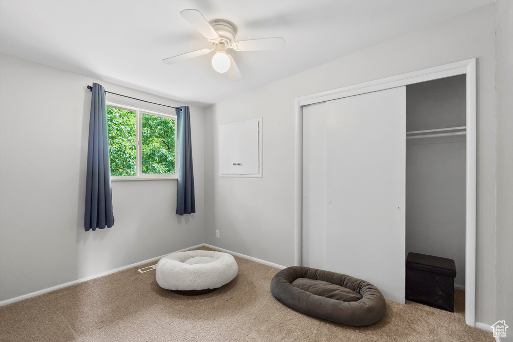 Carpeted bedroom featuring a closet and ceiling fan