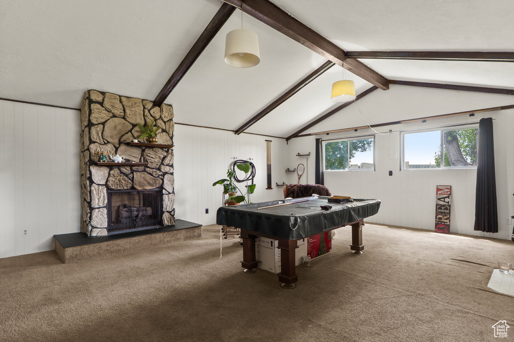 Recreation room featuring carpet flooring, pool table, a stone fireplace, and wooden walls