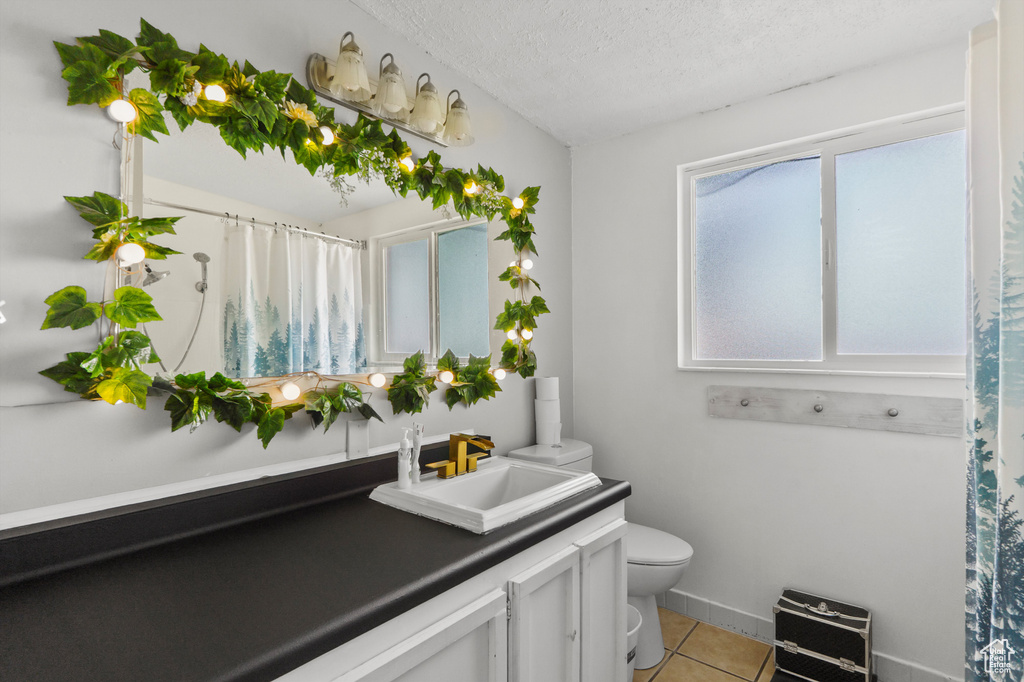 Bathroom featuring vanity, tile patterned flooring, a textured ceiling, and a shower with curtain