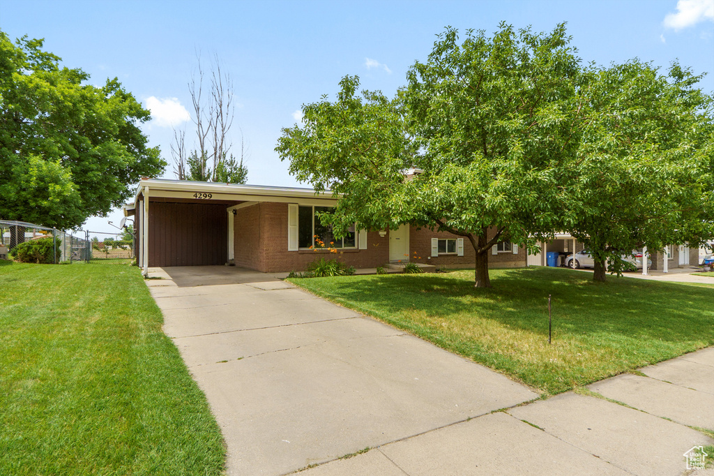 View of front facade featuring concrete driveway, an attached carport, and brick siding