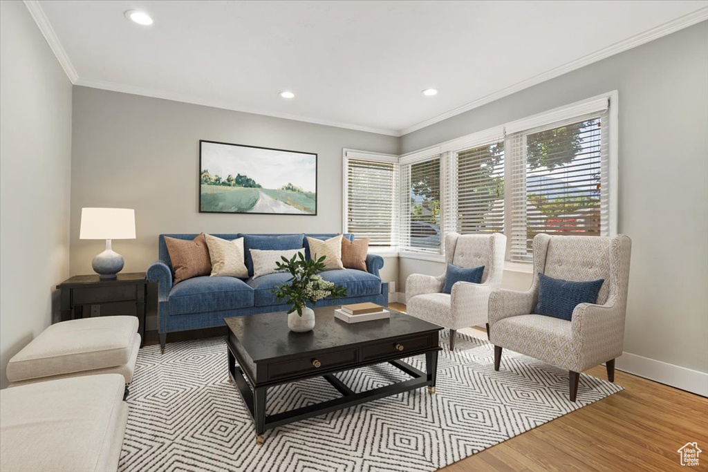 Living room with light wood-type flooring, recessed lighting, and ornamental molding
