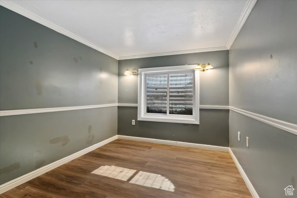 Empty room featuring crown molding and wood finished floors