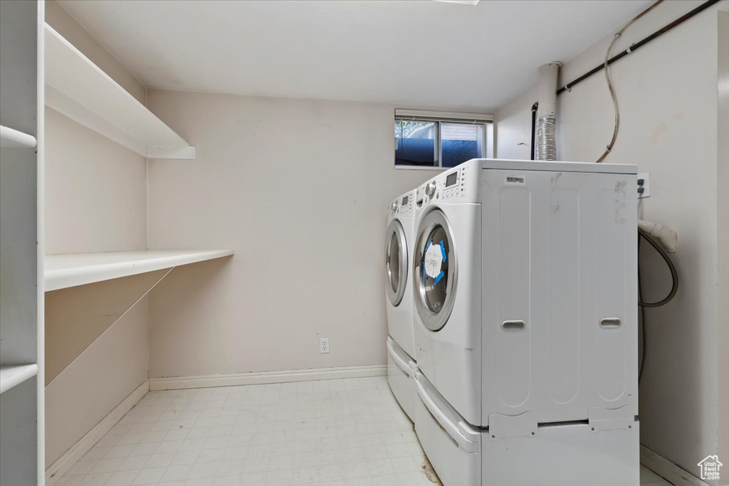 Washroom with washing machine and dryer and light flooring