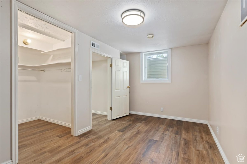 Unfurnished bedroom with wood finished floors and a closet