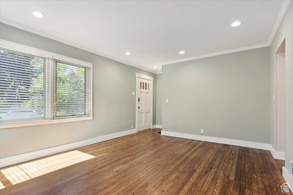 Empty room featuring crown molding, wood finished floors, and recessed lighting