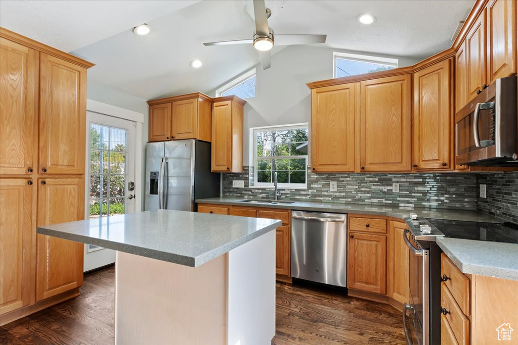 Kitchen with appliances with stainless steel finishes, vaulted ceiling, healthy amount of natural light, ceiling fan, and decorative backsplash