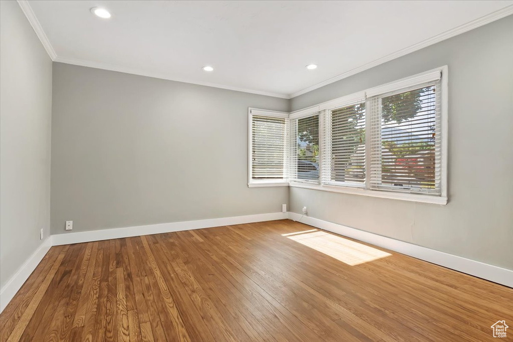 Spare room featuring ornamental molding, wood finished floors, and recessed lighting