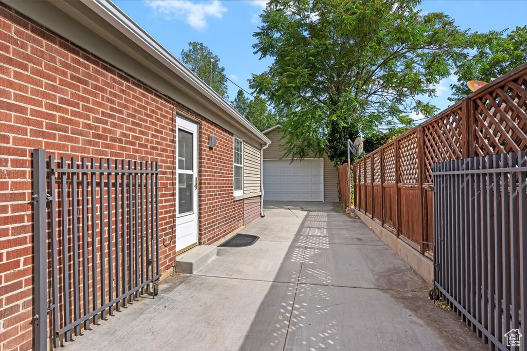 View of patio with a garage and an outbuilding
