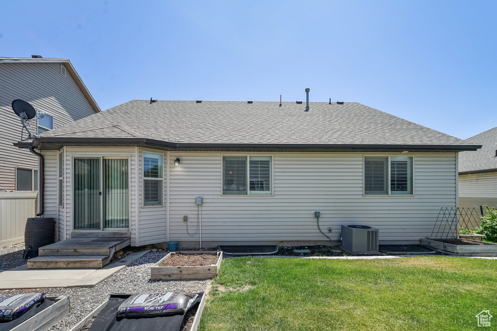 Rear view of property with a garden and roof with shingles