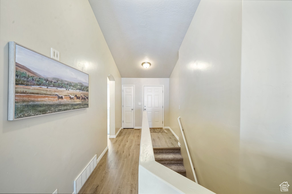 Hall with wood finished floors and arched walkways