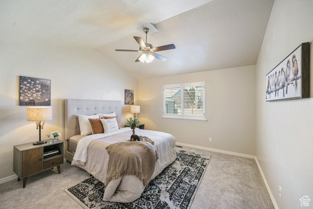 Bedroom with light carpet, lofted ceiling, and a ceiling fan