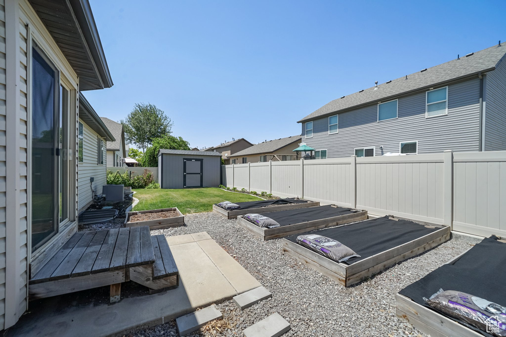 Fenced backyard with a storage shed and a residential view