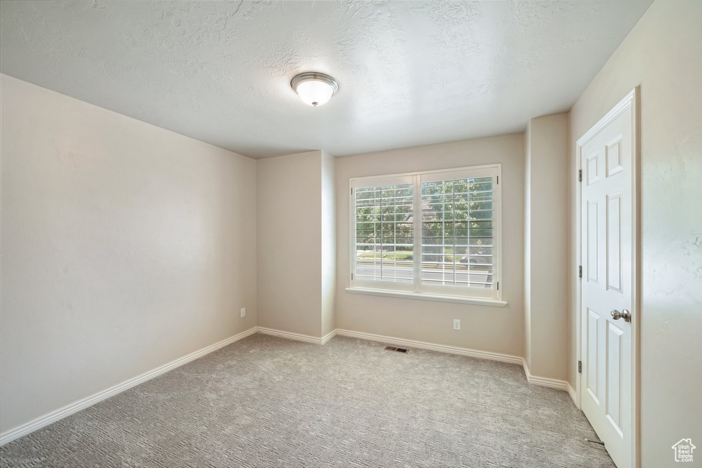 Unfurnished room with carpet floors and a textured ceiling