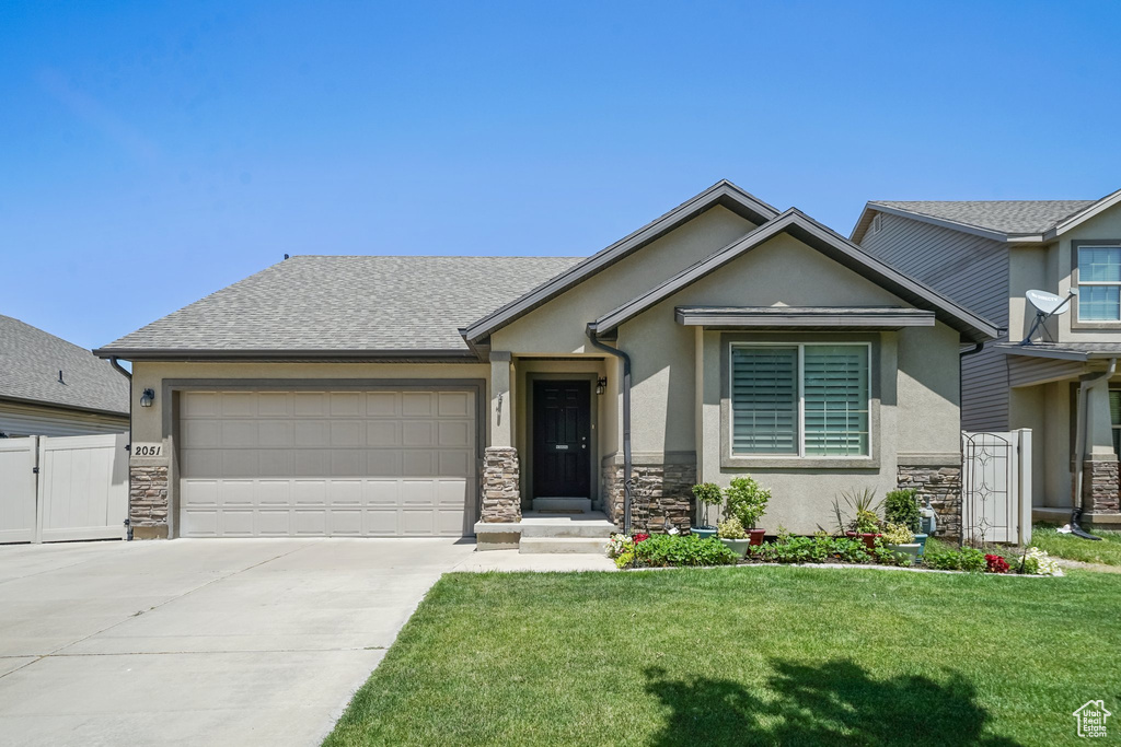 View of front of house featuring stone siding, stucco siding, an attached garage, and concrete driveway