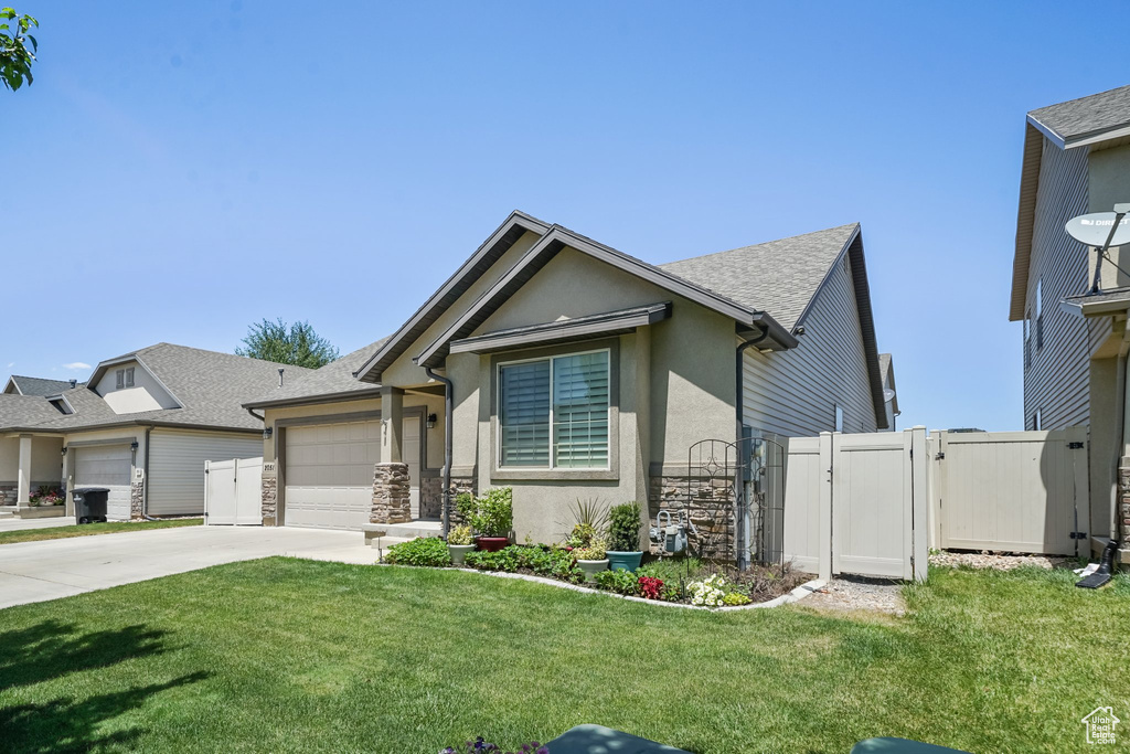 Single story home featuring stone siding, a gate, concrete driveway, an attached garage, and stucco siding