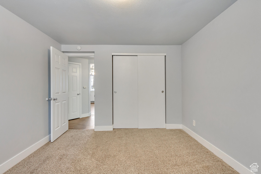Unfurnished bedroom with carpet flooring, baseboards, and a closet