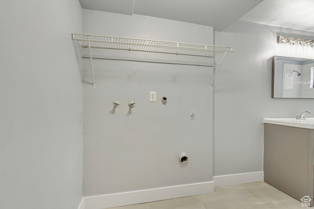 Laundry area featuring hookup for an electric dryer, baseboards, hookup for a gas dryer, and light tile patterned floors
