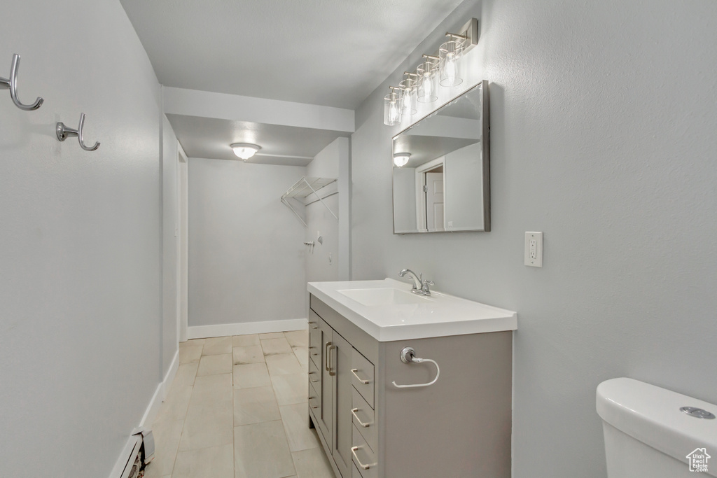 Bathroom with vanity, toilet, and baseboards