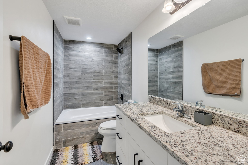 Full bath with vanity, recessed lighting, and tiled shower / bath