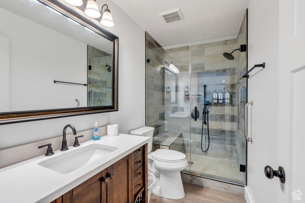 Full bathroom featuring vanity, a stall shower, and wood finished floors