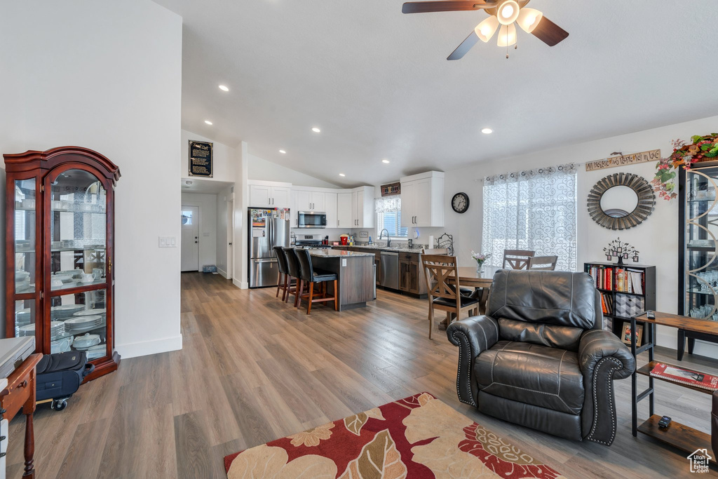 Living area with recessed lighting, ceiling fan, vaulted ceiling, and light wood-type flooring