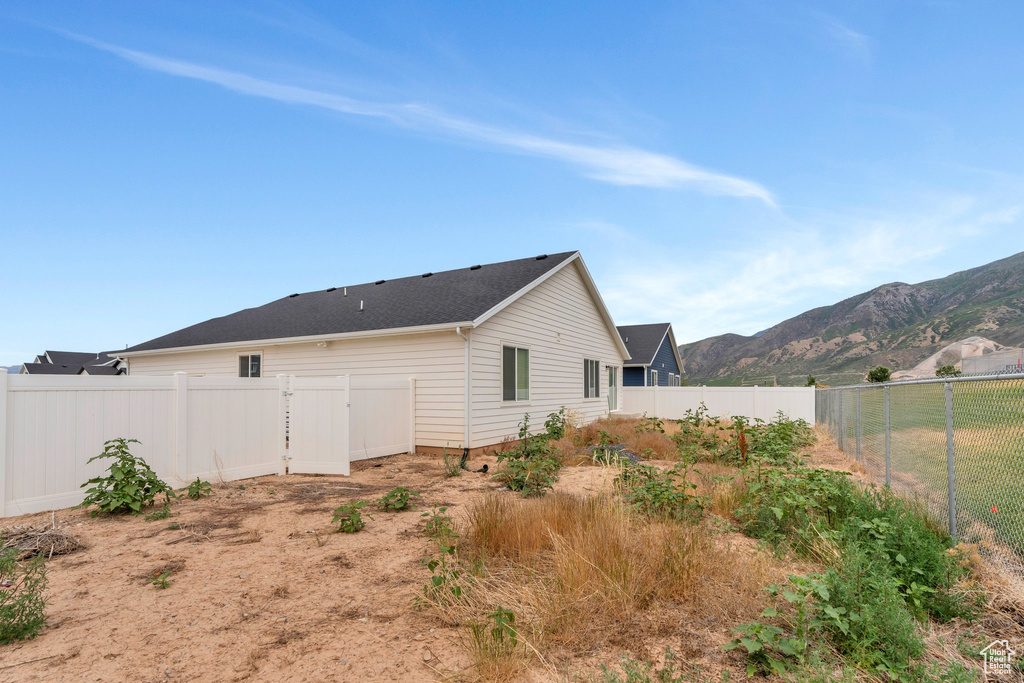 Back of property with a mountain view and a fenced backyard