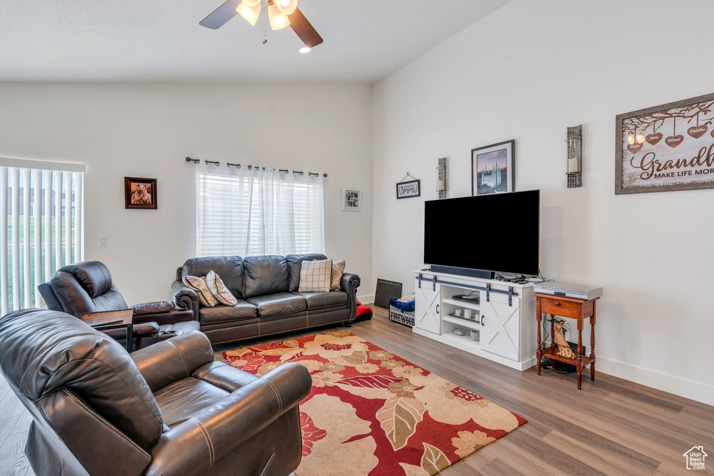 Living room featuring lofted ceiling, ceiling fan, and wood finished floors