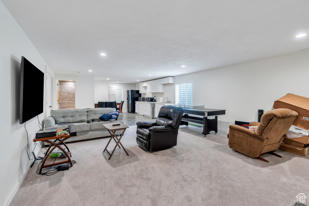 Living area with recessed lighting and light colored carpet