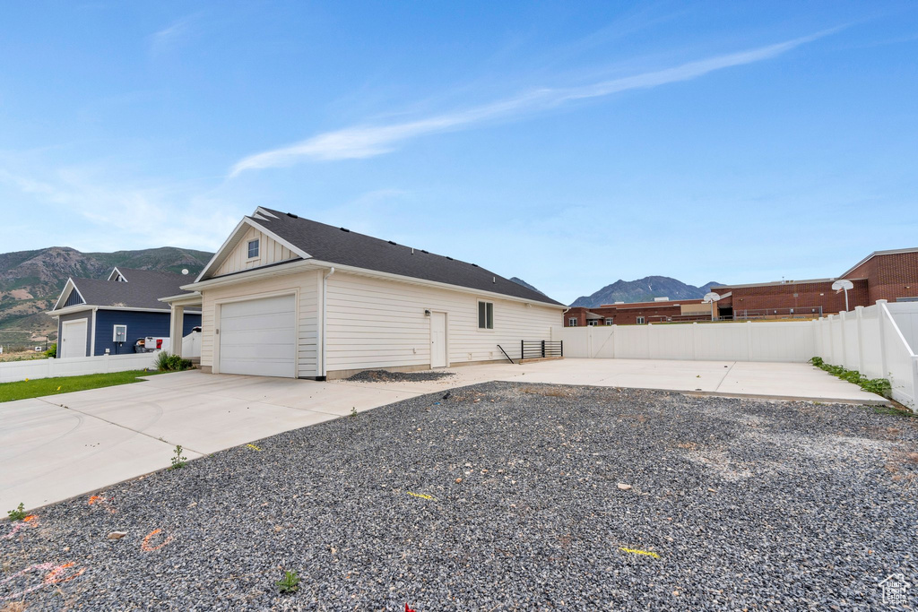 View of home's exterior with a mountain view, board and batten siding, a garage, and driveway