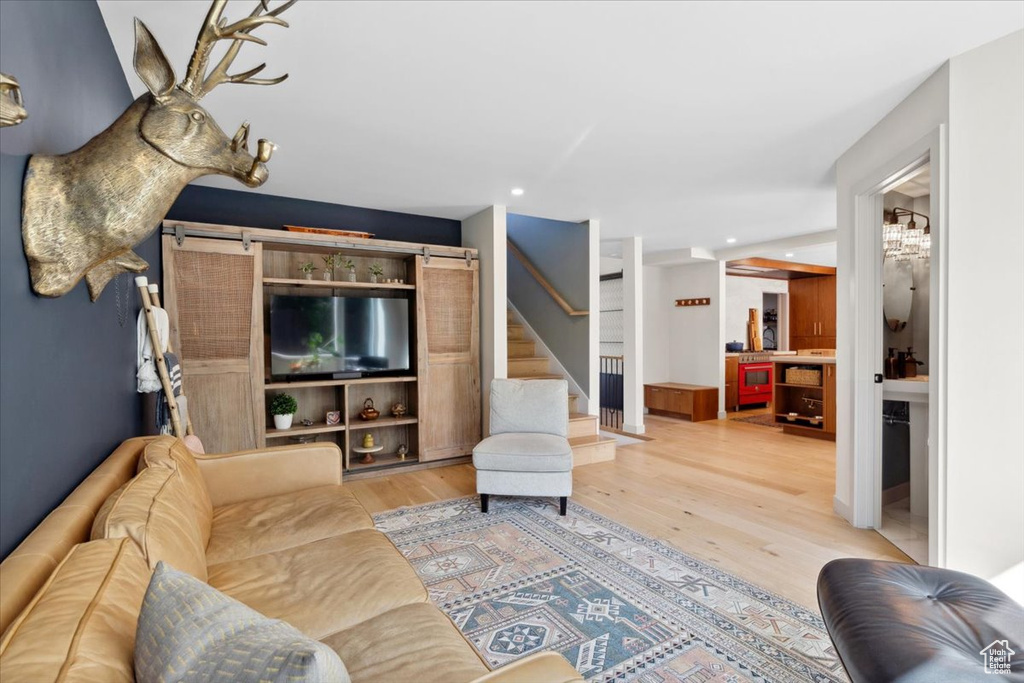 Living area featuring stairs, wood finished floors, recessed lighting, and a barn door