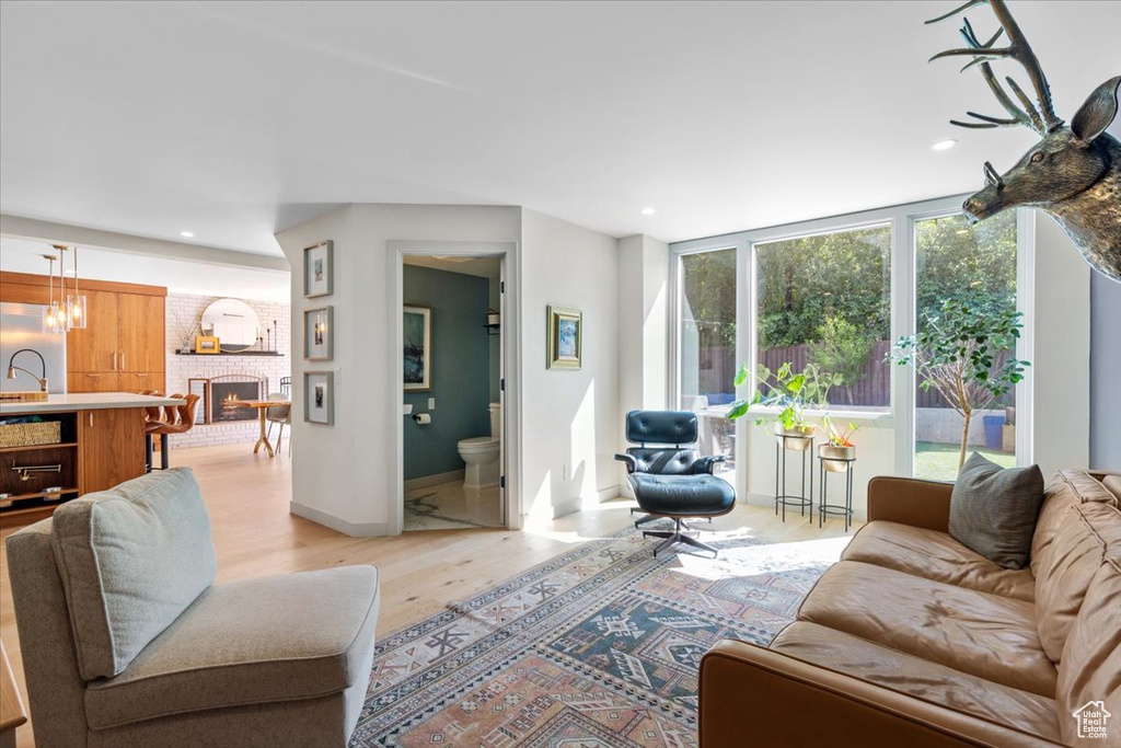 Living area featuring light wood-type flooring, a brick fireplace, and recessed lighting