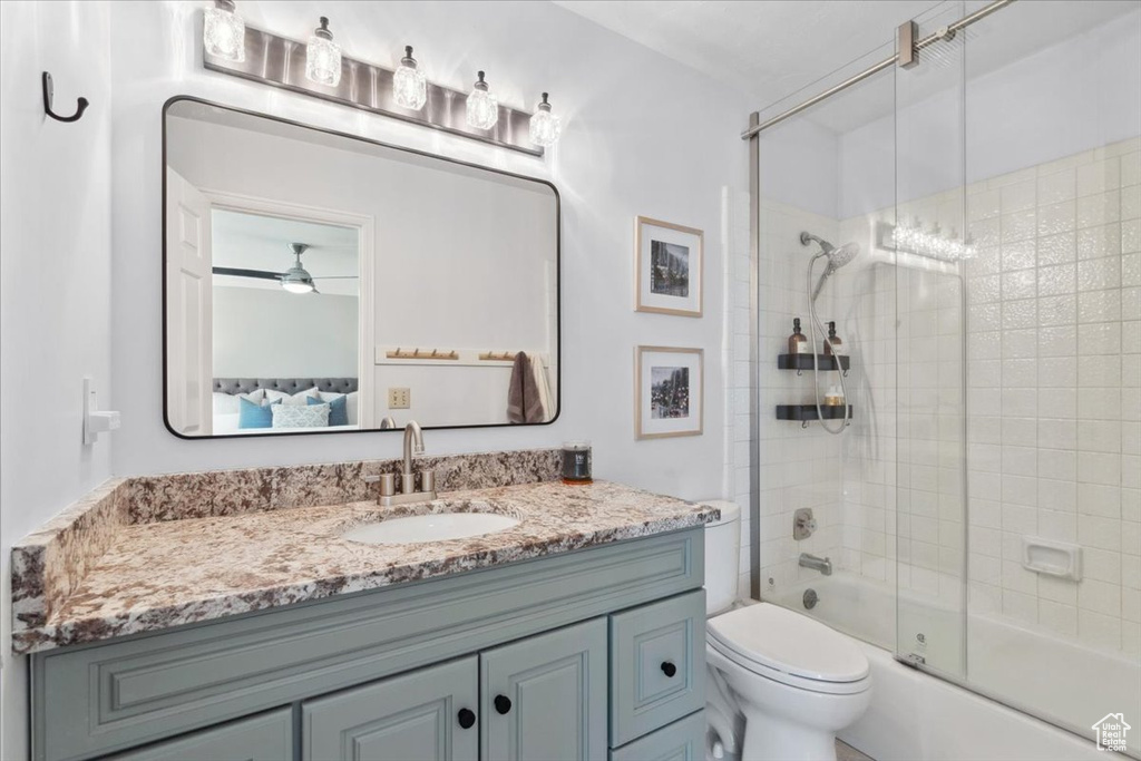 Full bathroom featuring ensuite bathroom, vanity, enclosed tub / shower combo, and a ceiling fan