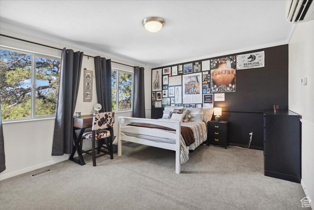 Bedroom featuring a wall mounted air conditioner, carpet, and crown molding