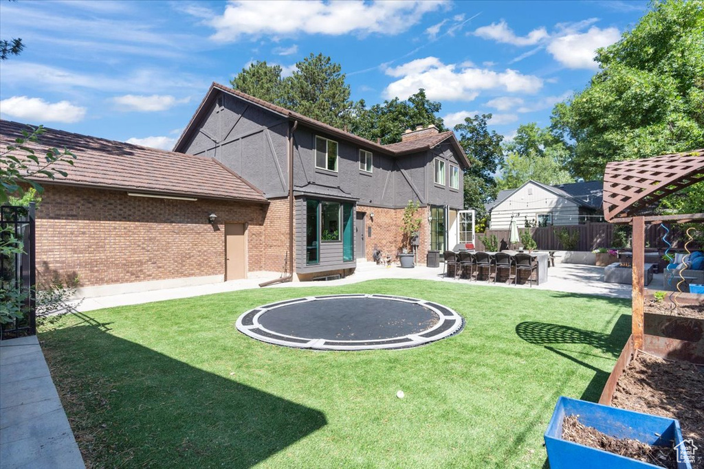 Rear view of property featuring a patio and brick siding
