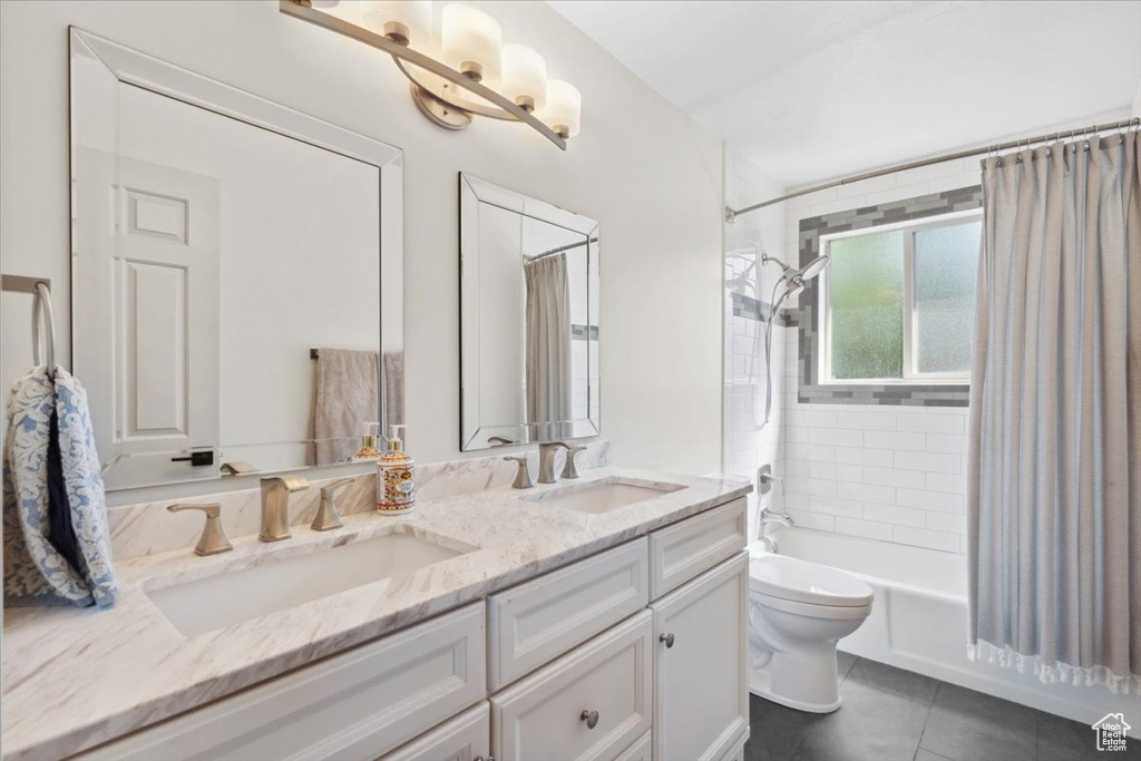 Bathroom with double vanity, tile patterned floors, and shower / bathtub combination with curtain