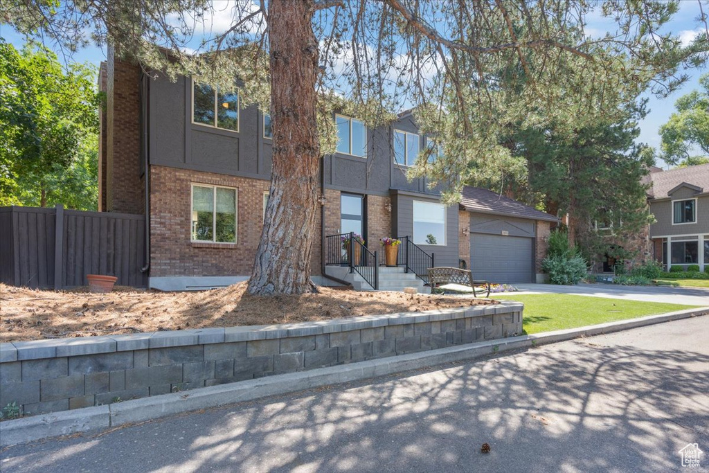 View of front of house with concrete driveway and brick siding