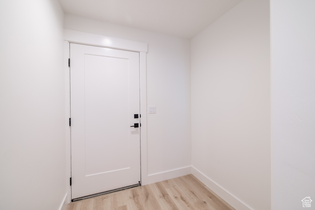 Doorway to outside featuring light wood-style flooring and baseboards