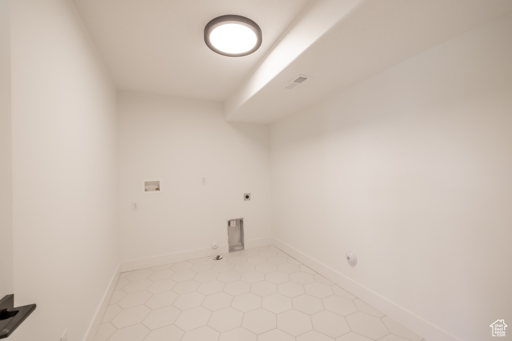 Washroom with gas dryer hookup, hookup for an electric dryer, washer hookup, and light tile patterned flooring