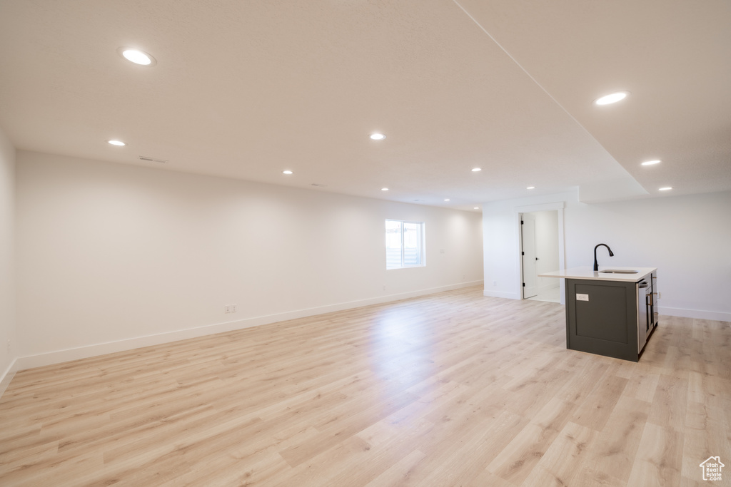 Below grade area featuring light wood finished floors and recessed lighting