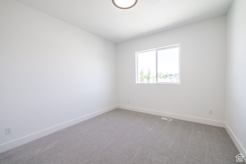 Empty room with carpet floors and baseboards