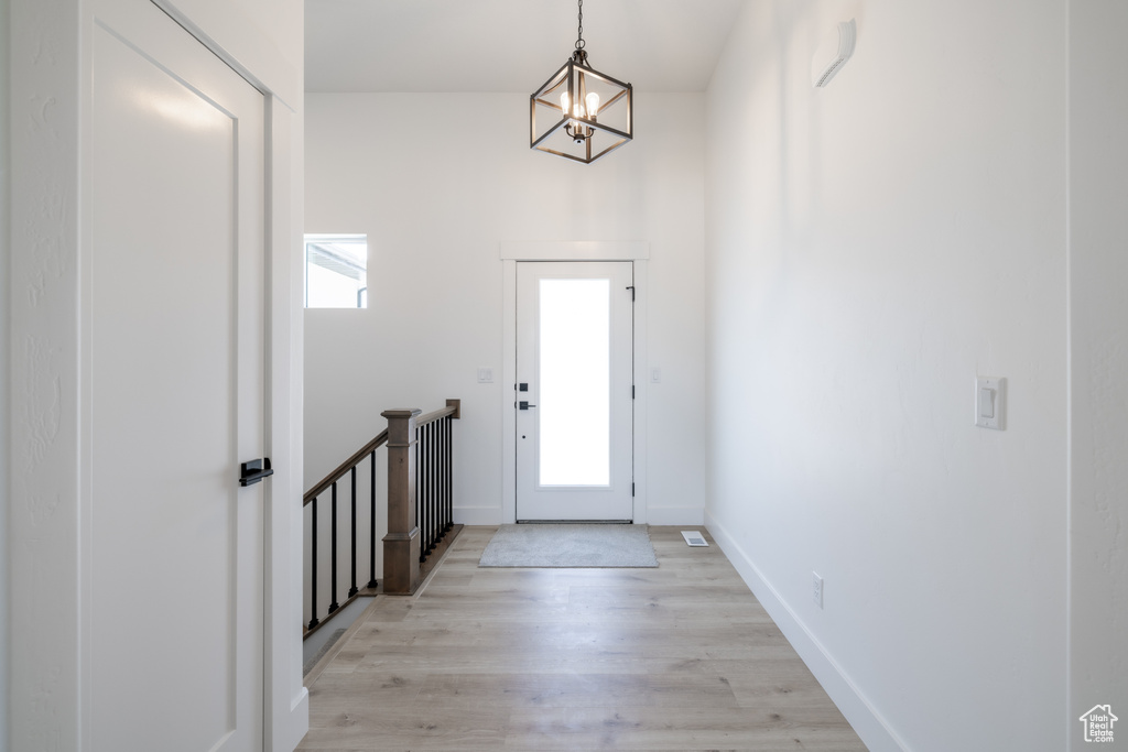Foyer entrance featuring a chandelier and light wood-style flooring