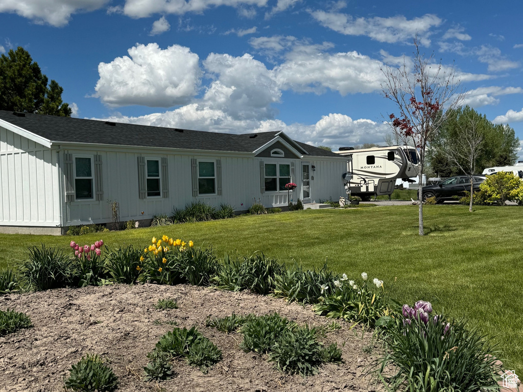 Back of house with a yard and board and batten siding