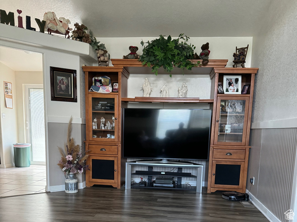 Living room featuring dark wood finished floors and a textured wall