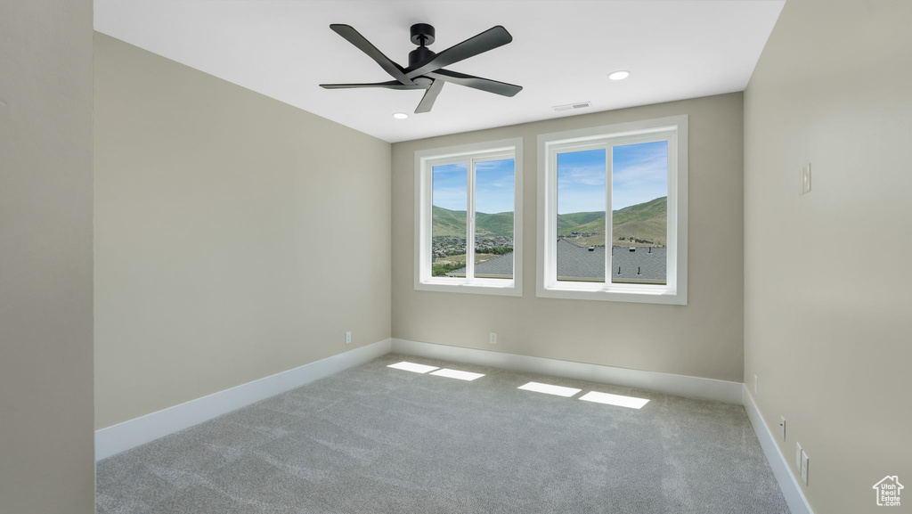 Carpeted empty room featuring ceiling fan and recessed lighting