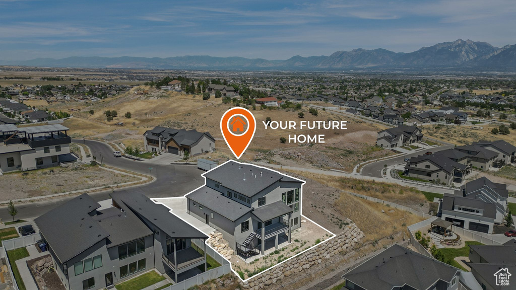 Aerial view of property's location featuring a mountainous background and nearby suburban area